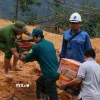 Tuyến Quốc lộ 40B bị sạt lở nặng, tuyến đường nối từ vùng đồng bằng về nhiều khu vực miền núi bị đình trệ hoàn toàn, hàng hóa tiếp tục được vận chuyển bằng sức người. (Ảnh: Đoàn Hữu Trung/TTXVN)