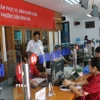 Cán bộ tiếp nhận hồ sơ giải quyết thủ tục cho người dân tại Trung tâm Phục vụ hành chính công phường Điện Biên Phủ (tỉnh Điện Biên) trong ngày đầu vận hành thử nghiệm. (Ảnh: Phan Quân/ TTXVN)