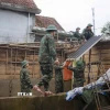 Lực lượng bộ đội ra quân giúp dân xây dựng và sửa chữa nhà cửa bị ảnh hưởng bởi mưa lũ tại xã Lộc An. (Ảnh: Mai Trang/TTXVN)