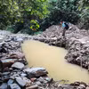 Khe Huổi Lúc bị nắn dòng bởi những hố sâu do khai thác vàng. (Ảnh: Văn Tý/TTXVN)