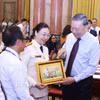 Tổng Bí thư, Chủ tịch nước Tô Lâm tặng quà lưu niệm cho các nhà báo tiêu biểu. (Ảnh: Văn Điệp/TTXVN)