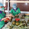 Người lao động làm bánh tét tại cơ sở sản xuất bánh tét Ba Loan, làng nghề bánh tét Trà Cuôn. (Ảnh: Thanh Hòa/TTXVN)