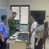 Kiểm sát viên Viện Kiểm sát Nhân dân tỉnh Thanh Hóa kiểm sát việc tống đạt Quyết định khởi tố và Lệnh tạm giam đối với bị can Trịnh Thị Vân Anh và Nguyễn Thị Thanh Ngần. (Ảnh: TTXVN phát)