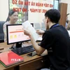 Cán bộ, công chức tiếp nhận và xử lý hồ sơ thủ tục hành chính cho người dân tại phường Việt Trì, tỉnh Phú Thọ. (Ảnh: Tạ Toàn/TTXVN)