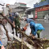 Công an xã Quỹ Nhất giúp người dân khắc phục hậu quả. (Ảnh: Công Luật/TTXVN)