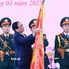 Thủ tướng Phạm Minh Chính gắn danh hiệu Anh hùng Lực lượng vũ trang lên Cờ truyền thống của Lực lượng vũ trang Thành phố Hồ Chí Minh. (Ảnh: Dương Giang/TTXVN)