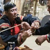 Nghi thức tháo vòng đồng 7 khấc và đeo vòng đồng mới cho người trưởng thành của dân tộc Ê Đê. (Ảnh: Lê Đông/TTXVN)