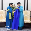 Bà Ngô Phương Ly, Phu nhân Tổng Bí thư Tô Lâm giới thiệu và tặng áo dài truyền thống Việt Nam cho bà Loo Tze Lui, Phu nhân Thủ tướng Singapore Lawrence Wong. (Ảnh: Phạm Kiên/TTXVN)
