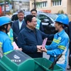 Thủ tướng Phạm Minh Chính thăm, chúc Tết công nhân đang thu gom, vận chuyển, xử lý rác thải khu vực Yên Thế-Nguyễn Thái Học. (Ảnh: Dương Giang/TTXVN)