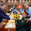 Tổng Bí thư, Chủ tịch nước Tô Lâm tặng hoa chúc mừng các đảng viên nhận Huy hiệu Đảng. (Ảnh: Thống Nhất/TTXVN)