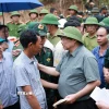 Thủ tướng Phạm Minh Chính động viên đồng bào xã Xa Dung bị thiệt hại do mưa lũ. (Ảnh: Dương Giang/TTXVN)