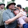 Thủ tướng Phạm Minh Chính động viên gia đình có người chết do mưa lũ ở xã Xa Dung. (Ảnh: Dương Giang/TTXVN)