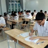 Các thí sinh ghi thông tin trên bài thi. (Ảnh: Nguyễn Lành/ TTXVN)