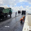 Thi công trải thảm nhựa nóng mặt cầu Đại Ngãi 2, ngày 4/5. (Ảnh: Trung Hiếu/TTXVN)