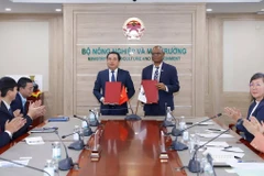 Bộ trưởng Bộ Nông nghiệp và Môi trường Trần Đức Thắng và ông Martin Kabaluapa, Tổng Giám đốc các văn phòng của Tổ chức Quốc tế về Bảo tồn Thiên nhiên (WWF) ký Biên bản ghi nhớ hợp tác (MOU) mới. (Ảnh: Khương Trung).