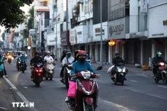 Người dân trong trang phục giữ ấm đi làm trên đường Hồ Văn Huê (phường Đức Nhuận) thời điểm 6 giờ 20 phút sáng 9/1/2026. (Ảnh: Hồng Đạt/TTXVN)