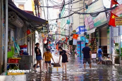 Người dân Phú Đô hối hả dọn dẹp để trở lại cuộc sống thường nhật. (Ảnh: Bảo Ngọc/ Vietnam+)