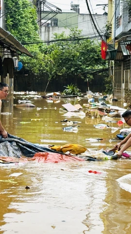 Người dân dọn dẹp nhà cửa sau trận lụt. (Ảnh: Đức Thọ/TTXVN)