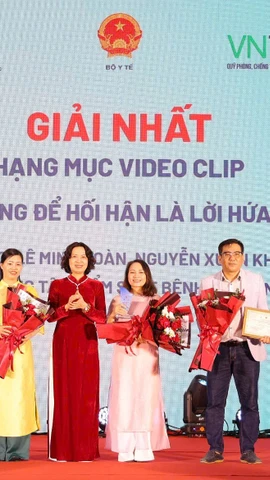Thứ trưởng Bộ Y tế trao cho các tác giả đoạt Giải Nhất ở Hạng mục video clip. (Ảnh: PV/Vietnam+)
