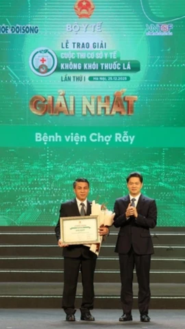 Thứ trưởng Thường trực Bộ Y tế trao giấy chứng nhận và tặng hoa cho Cơ sở y tế đạt giải Nhất. (Ảnh: PV/Vietnam+)