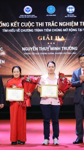 Ban Tổ chức trao chứng nhận và hoa cho các tác giả đoạt giải. (Ảnh: PV/Vietnam+)