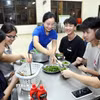 Học sinh khối lớp 12, Trường THPT Dân tộc Nội trú tỉnh Lạng Sơn vui vẻ nhận những phần cháo, ăn đêm để đảm bảo sức khỏe trong suốt kỳ thi. (Ảnh: Văn Đạt/TTXVN)