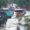 Chân dốc Minh Khai mênh mông nước, người dân gặp nhiều khó khăn khi cố gắng di chuyển. (Ảnh: Thanh Tùng/TTXVN)