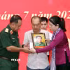 Phút nghẹn ngào của thân nhân liệt sỹ đón nhận di ảnh liệt sỹ đã được phục dựng. (Ảnh: Xuân Khu/TTXVN)