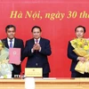 Thủ tướng Phạm Minh Chính trao quyết định và tặng hoa chúc mừng đồng chí Trần Đức Thắng (phải), Phó Tổng Thanh tra Thường trực Thanh tra Chính phủ và đồng chí Hồ Văn Niên, Thứ trưởng Thường trực Bộ Dân tộc và Tôn giáo. (Ảnh: Dương Giang/TTXVN)