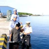 Cán bộ, chiến sỹ thị trấn Trường Sa đưa ông Trần Công Nhanh trở lại tàu để rời đảo. (Ảnh: TTXVN phát)