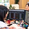 Khách hàng giao dịch chứng khoán. (Ảnh: Trần Việt/TTXVN)