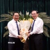 Ông Nguyễn Văn Nên (phải), Ủy viên Bộ Chính trị, Bí thư Thành ủy Thành phố Hồ Chí Minh chúc mừng Chủ tịch Ủy ban Nhân dân Thành phố Hồ Chí Minh Nguyễn Văn Được. (Ảnh: Xuân Khu/TTXVN)