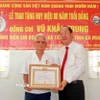 Bí thư Tỉnh ủy Cà Mau Nguyễn Hồ Hải trao Huy hiệu 80 năm tuổi Đảng cho đảng viên Vũ Khắc Trung (sinh năm 1928) tại xã Tân Lộc, tỉnh Cà Mau. (Ảnh: Huỳnh Anh/TTXVN)