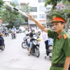 Lực lượng chức năng phân luồng giao thông trước cổng điểm thi THPT Nguyễn Trãi-Ba Đình. (Ảnh: Lê Đông/TTXVN)
