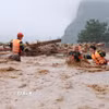 Lực lượng cứu nạn cứu hộ Công an tỉnh Lai Châu căng dây giữa dòng nước lũ đưa người dân xã Mường Than ra khỏi vùng bị cô lập nguy hiểm đến nơi ở an toàn. (Ảnh: Quý Trung/TTXVN)