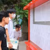 Thí sinh xem số báo danh dự thi vào lớp 10. (Ảnh: Hoàng Hiếu/TTXVN)