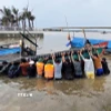 Lực lượng Bộ đội Biên phòng Quảng Trị phối hợp với lực lượng liên quan tiến hành trục vớt tàu, thuyền của ngư dân bị ảnh hưởng sau bão. (Ảnh: TTXVN phát)