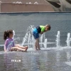 Trẻ em giải nhiệt tránh nóng tại một đài phun nước. (Ảnh: THX/TTXVN)