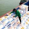 Gạo xuất khẩu tập kết xuống ghe ở tỉnh An Giang. (Ảnh: Hồng Đạt/TTXVN)