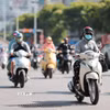 Người dân sử dụng khẩu trang, áo chống nắng giúp tránh nóng bức khi tham gia giao thông. (Ảnh: Lê Đông/TTXVN)