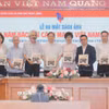 Tổng giám đốc TTXVN Vũ Việt Trang tặng sách ảnh cho các đại biểu. (Ảnh: Minh Quyết/TTXVN)