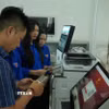 Hỗ trợ người dân khi làm thủ tục trực tuyến. (Ảnh: Hữu Duyên/TTXVN)