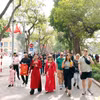 Du khách trong nước và quốc tế thảnh thơi du xuân bên hồ Hoàn Kiếm. (Ảnh: Phạm Kiên/TTXVN)