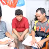 Các cử tri khiếm thị thích thú với tài liệu bầu cử được in bằng chữ nổi. (Ảnh: Xuân Khu/TTXVN)