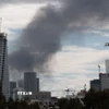Khói bốc lên từ thành phố Tel Aviv, Israel sau cuộc tấn công đáp trả của Iran. (Ảnh: THX/TTXVN)