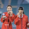 Trần Thị Loan (phải) giành HCV nội dung nhảy xa nữ cùng Hà Thị Thuý Hằng giành HCB trên bục nhận huy chương. (Ảnh: Minh Quyết/TTXVN)