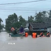 Lực lượng chức năng Phường Sông Cầu tổ chức cứu nạn người dân ở khu vực ngập sâu. (Ảnh: TTXVN phát)
