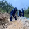 Các lực lượng đào, vét đất đá, mở rãnh thoát nước và thu dọn bùn đất tràn xuống mặt đường, tạo lối đi tạm để phương tiện qua lại. (Ảnh: TTXVN phát)