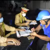 Lực lượng cảnh sát giao thông tỉnh Kiên Giang lập biên bản vi phạm hành chính người tham gia giao thông. (Ảnh: Lê Sen/TTXVN)