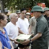 Phó Thủ tướng Trần Hồng Hà tặng quà các hộ bị ngập hoàn toàn. (Ảnh: Chu Hiệu/TTXVN)